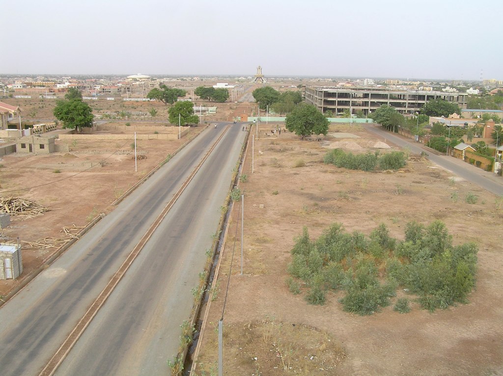 Voie bitumée bordée de parcelles en cours d'urbanisation à Ouaga 2000